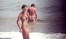黒髪の裸の女の子がビーチで裸で歩き回る
