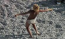 Zábavná blondýnka tančí v písku